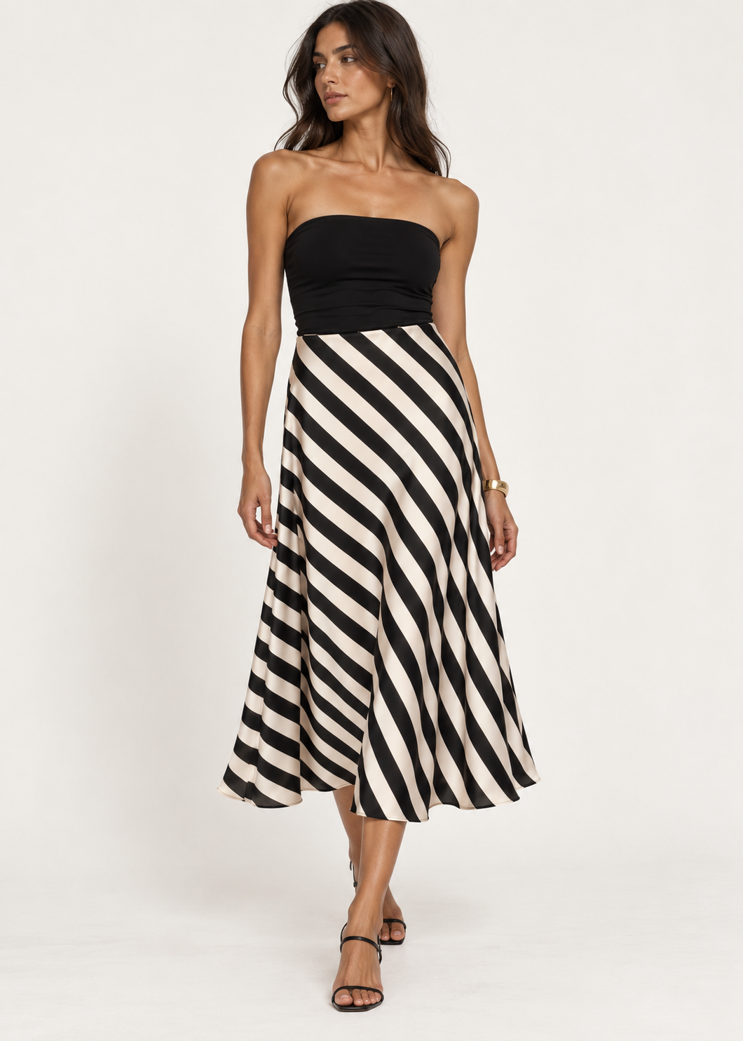 Model wearing a black-and-cream diagonal-stripe midi skirt with a fitted black top