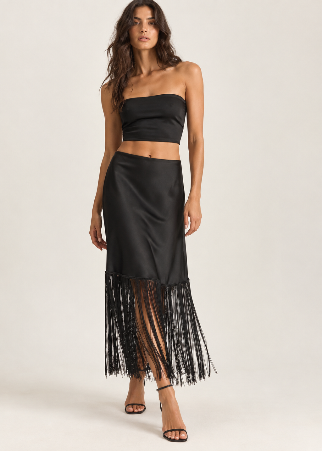 Black midi skirt with a long fringe hem shown against a white background