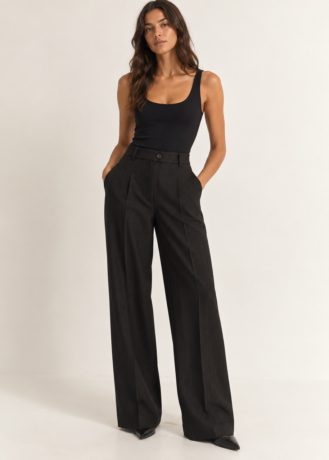 Model wearing black high-waisted wide-leg trousers with a fitted black top