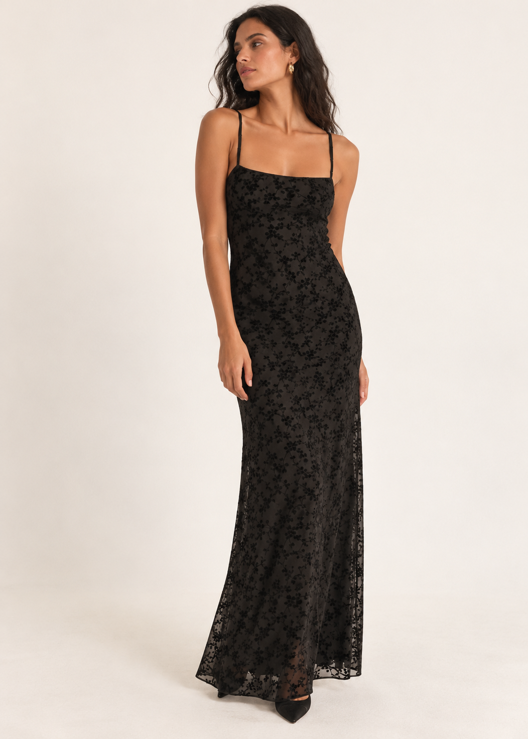 Model wearing black floral maxi slip dress with a softly squared neckline and black pointed heels