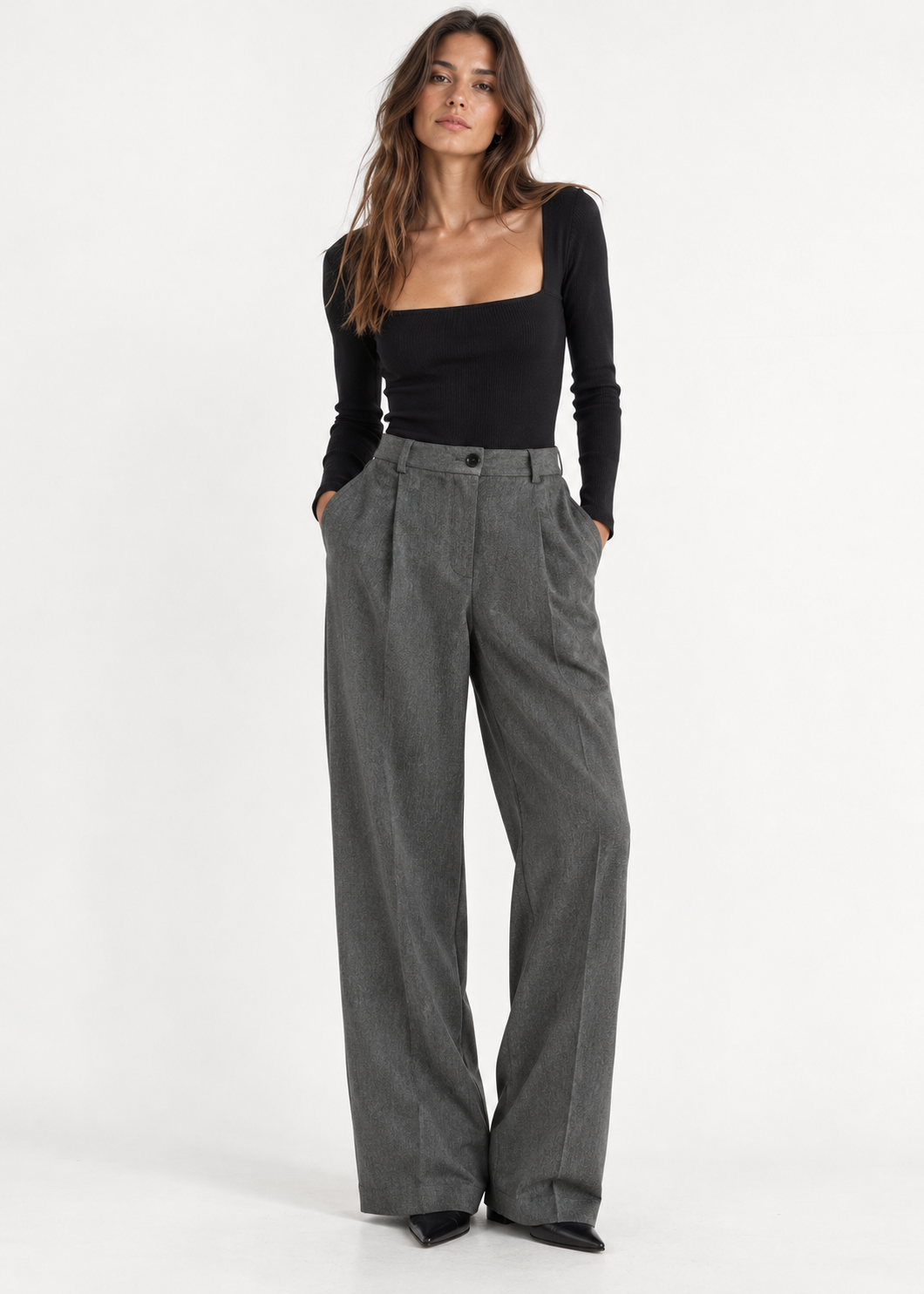 Model wearing charcoal grey pleated wide-leg trousers with a fitted black square-neck top