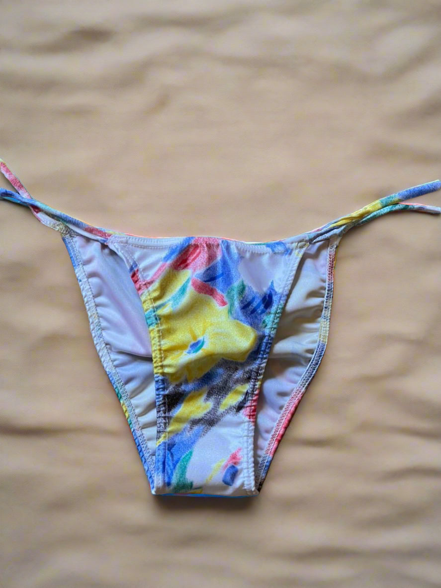 Colorful bikini bottom on a textured woven surface