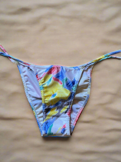 Colorful bikini bottom on a textured woven surface
