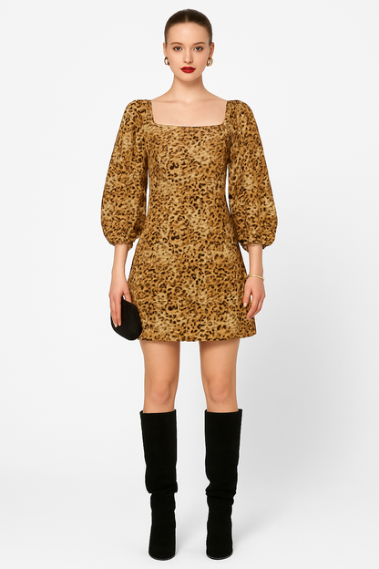 Woman wearing a leopard print dress with puff sleeves and black knee-high boots on a white background